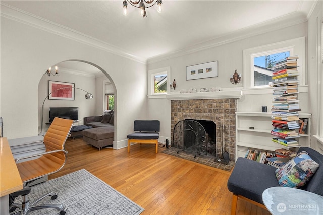 4228 1st Ave NE, Seattle, WA 98105 - living room featuring arched walkways, wood-type flooring, a fireplace with flush hearth, crown molding, and a chandelier