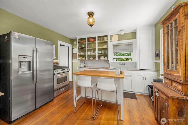 4228 1st Ave NE, Seattle, WA 98105 - kitchen featuring appliances with stainless steel finishes, butcher block counters, tasteful backsplash, open shelves, and dark wood-style floors