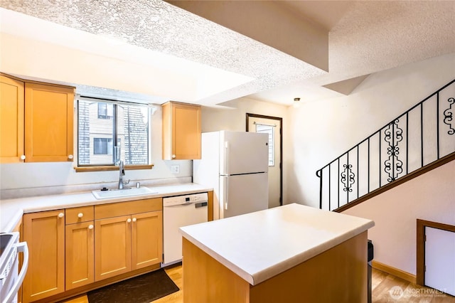 8605 244th St SW Unit 3F, Edmonds, WA 98026 - kitchen with white appliances, light wood-style flooring, a kitchen island, light countertops, and a textured ceiling