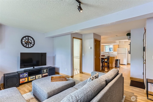 8605 244th St SW Unit 3F, Edmonds, WA 98026 - living area featuring light wood-style floors, a textured ceiling, and rail lighting
