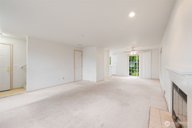 1160 Monroe Ave NE Unit B-4, Renton, WA 98056 - unfurnished living room featuring a tiled fireplace, light colored carpet, and ceiling fan
