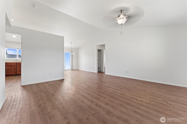 1325 W Polo Ridge Dr, Moses Lake, WA 98837 - unfurnished living room with vaulted ceiling, a ceiling fan, wood finished floors, and a chandelier