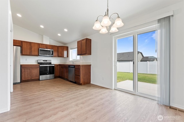 1325 W Polo Ridge Dr, Moses Lake, WA 98837 - kitchen with appliances with stainless steel finishes, light wood-style floors, a chandelier, light countertops, and lofted ceiling