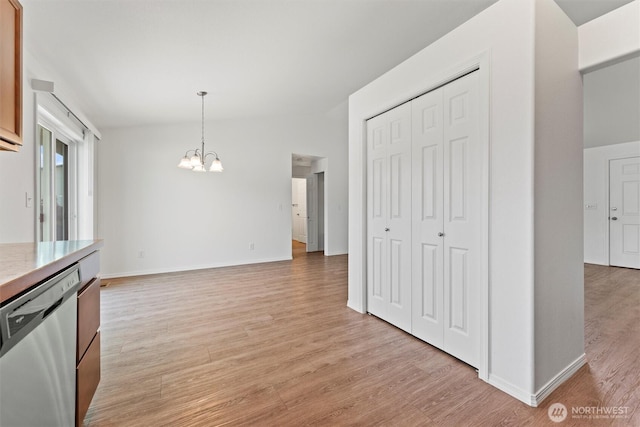 1325 W Polo Ridge Dr, Moses Lake, WA 98837 - kitchen featuring stainless steel dishwasher, a chandelier, lofted ceiling, light wood finished floors, and decorative light fixtures