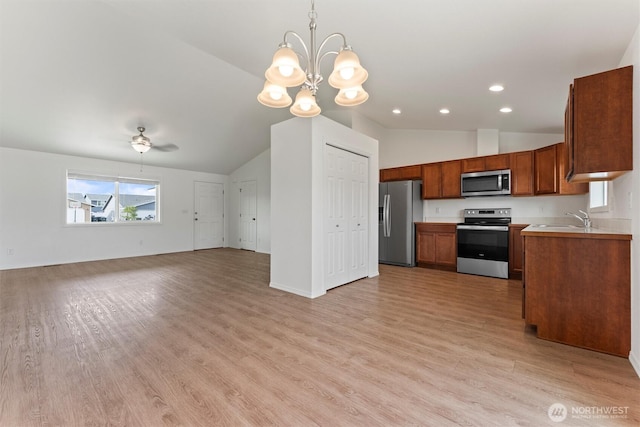 1325 W Polo Ridge Dr, Moses Lake, WA 98837 - kitchen with stainless steel appliances, vaulted ceiling, open floor plan, light wood-type flooring, and a chandelier