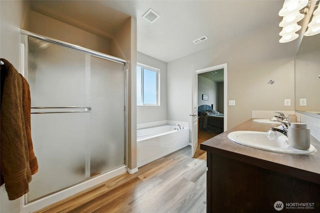 2134 Alco Ave, Walla Walla, WA 99362 - ensuite bathroom featuring a garden tub, a stall shower, double vanity, wood finished floors, and a chandelier