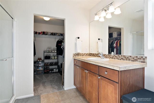 6672 Udall Pl SE, Auburn, WA 98092 - bathroom with a spacious closet, vanity, a shower stall, and decorative backsplash