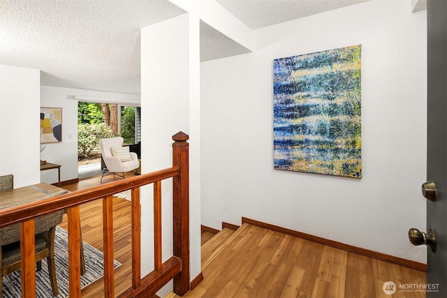 4727 W Lake Sammamish Pkwy SE Unit B-106, Issaquah, WA 98027 - hallway featuring wood finished floors, a textured ceiling, and an upstairs landing
