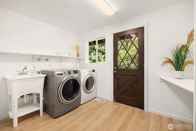10376 NE Winthers Rd, Bainbridge Island, WA 98110 - washroom with washing machine and dryer and light wood-type flooring