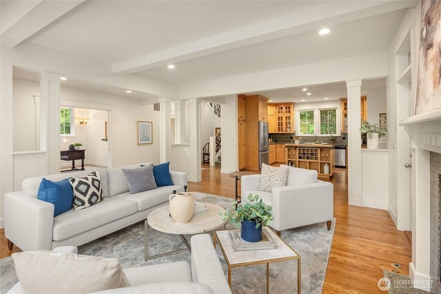473 Glen Hollow Pl SW, Bainbridge Island, WA 98110 - living room featuring decorative columns, light wood-style flooring, recessed lighting, beamed ceiling, and a fireplace