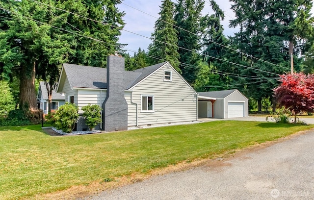 318 Mill Ave SE, Orting, WA 98360 - view of side of home with a chimney, a lawn, driveway, crawl space, and an outdoor structure