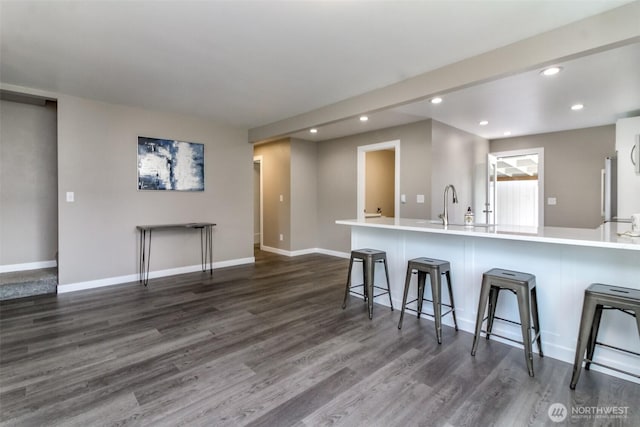 318 Mill Ave SE, Orting, WA 98360 - kitchen featuring recessed lighting, dark wood-style floors, a kitchen breakfast bar, and light countertops