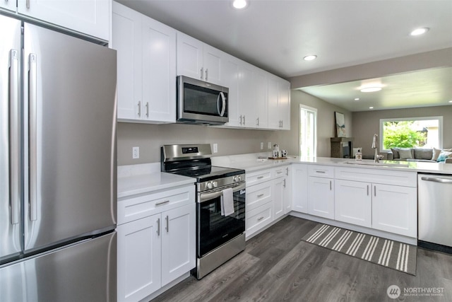 318 Mill Ave SE, Orting, WA 98360 - kitchen with appliances with stainless steel finishes, light countertops, white cabinets, dark wood finished floors, and recessed lighting