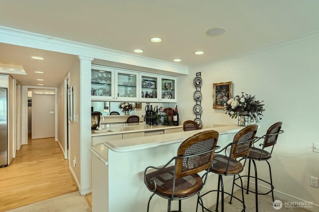 9727 NE Juanita Dr Unit 201, Kirkland, WA 98034 - indoor bar with ornamental molding, recessed lighting, stainless steel fridge, and light wood-style floors