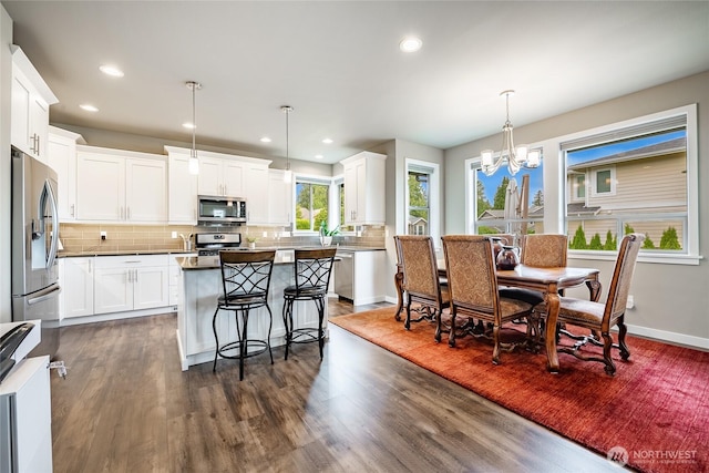 5417 Ocean Mist Loop, Blaine, WA 98230 - kitchen with appliances with stainless steel finishes, a center island, dark wood-style floors, a chandelier, and backsplash