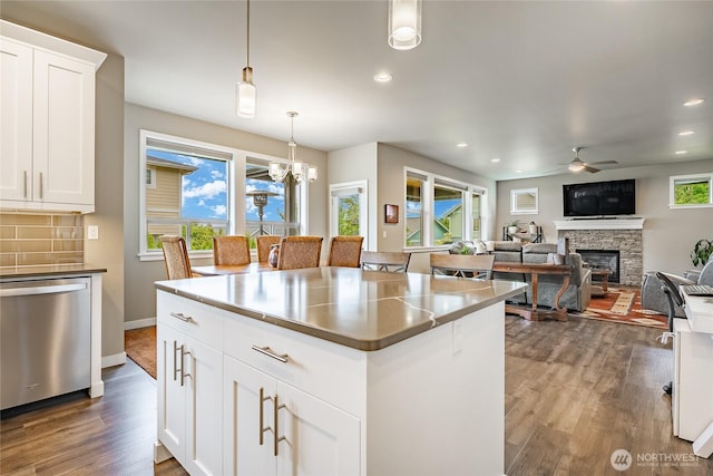 5417 Ocean Mist Loop, Blaine, WA 98230 - kitchen with dishwasher, ceiling fan, a fireplace, dark wood-type flooring, and a kitchen island