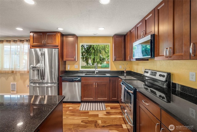 118 W Winesap Rd, Bothell, WA 98012 - kitchen featuring stainless steel appliances, light wood finished floors, recessed lighting, dark stone counters, and a textured ceiling