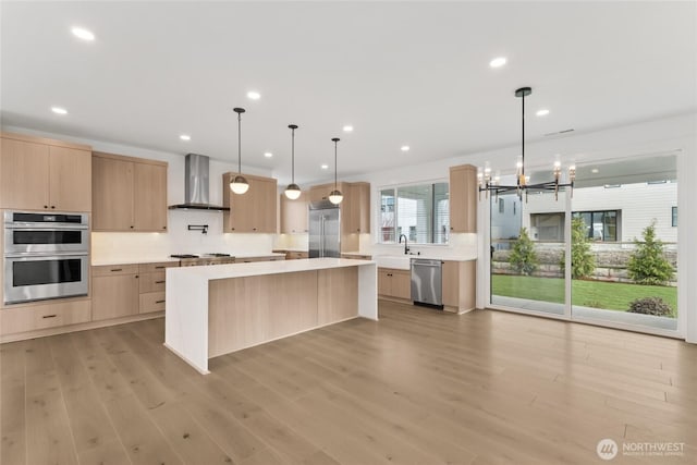 8517 137th Ave SE Unit 1, Newcastle, WA 98059 - kitchen with wall chimney range hood, light brown cabinetry, stainless steel appliances, light countertops, and recessed lighting