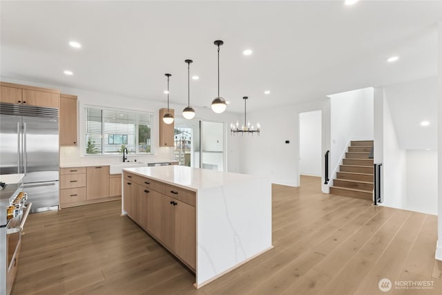 8517 137th Ave SE Unit 1, Newcastle, WA 98059 - kitchen with light brown cabinetry, high end appliances, a kitchen island, recessed lighting, and light countertops