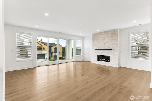 8517 137th Ave SE Unit 1, Newcastle, WA 98059 - unfurnished living room featuring a stone fireplace, healthy amount of natural light, wood finished floors, and recessed lighting