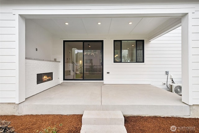 8517 137th Ave SE Unit 1, Newcastle, WA 98059 - doorway to property with a warm lit fireplace and a patio area