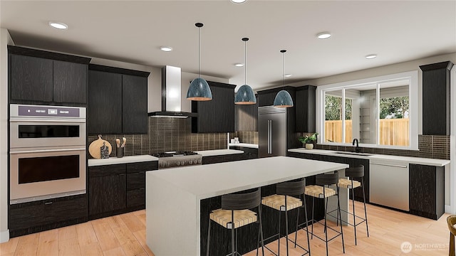 8517 137th Ave SE Unit 1, Newcastle, WA 98059 - kitchen with wall chimney exhaust hood, dark cabinets, a kitchen island, stainless steel appliances, and light countertops