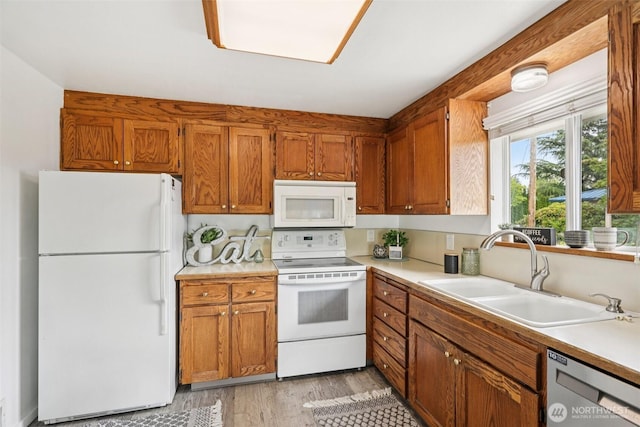 115 7th Ave SW, Puyallup, WA 98371 - kitchen featuring white appliances, light wood-type flooring, brown cabinetry, and light countertops