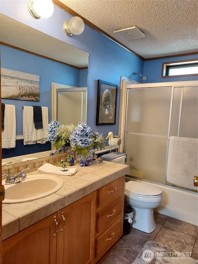 8430 15th Pl SE Unit 33, Lake Stevens, WA 98258 - full bath with vanity, bath / shower combo with glass door, a textured ceiling, ornamental molding, and tile patterned flooring