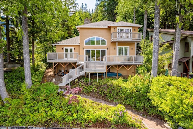 33571 Cliff Rd, Mount Vernon, WA 98274 - rear view of house with a balcony, stairway, a chimney, a wooden deck, and french doors
