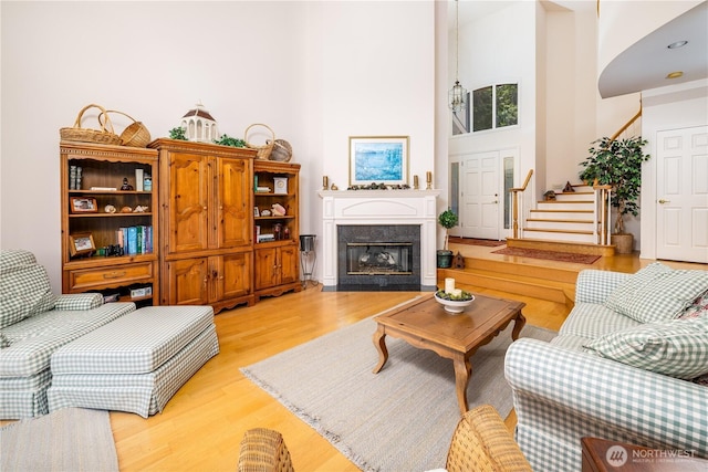 33571 Cliff Rd, Mount Vernon, WA 98274 - living area featuring light wood-style floors, a towering ceiling, a high end fireplace, and stairway