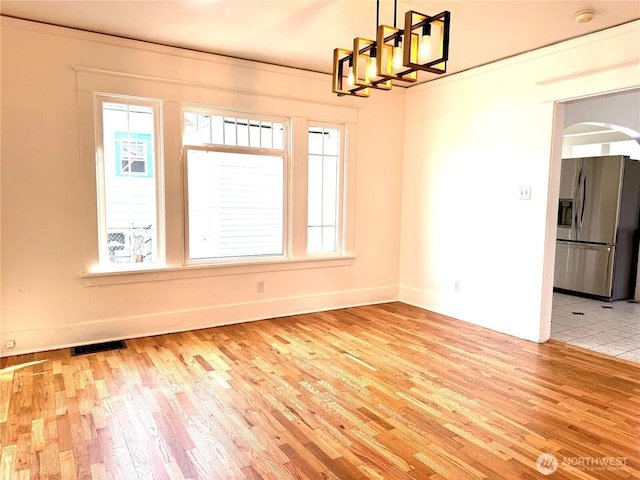 608 N Puget Sound Ave, Tacoma, WA 98406 - spare room featuring light wood-style floors, arched walkways, a smoke detector, and a chandelier