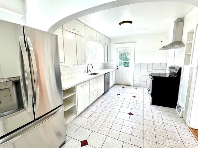608 N Puget Sound Ave, Tacoma, WA 98406 - kitchen featuring stainless steel appliances, wall chimney exhaust hood, open shelves, white cabinetry, and arched walkways