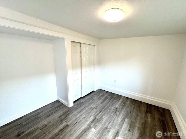 608 N Puget Sound Ave, Tacoma, WA 98406 - unfurnished bedroom featuring dark wood-type flooring and a closet