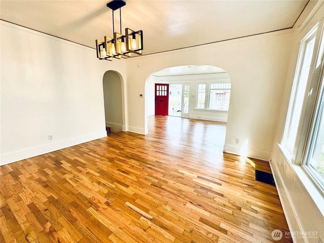 608 N Puget Sound Ave, Tacoma, WA 98406 - empty room with arched walkways, a chandelier, and light wood-type flooring