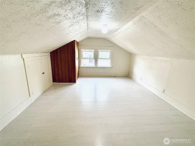 608 N Puget Sound Ave, Tacoma, WA 98406 - additional living space with lofted ceiling, a textured ceiling, and light wood-style flooring
