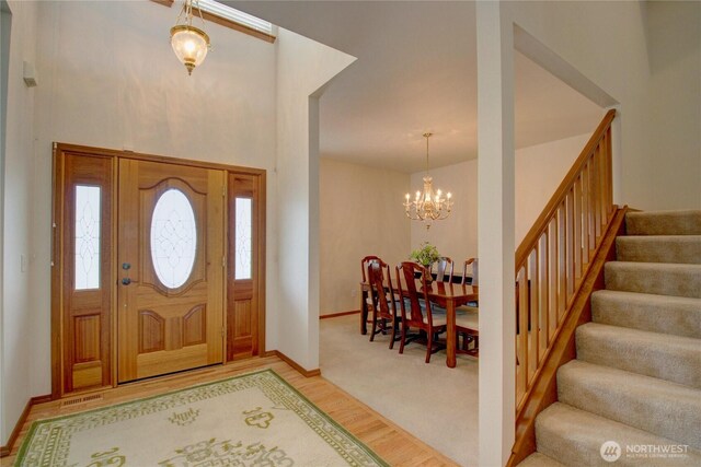 1218 Alpine View Dr, Mount Vernon, WA 98274 - entrance foyer with a chandelier, stairway, light wood-style floors, and a towering ceiling
