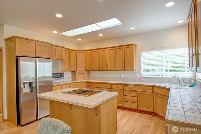 1218 Alpine View Dr, Mount Vernon, WA 98274 - kitchen featuring stainless steel appliances, tile counters, a skylight, light wood-type flooring, and recessed lighting