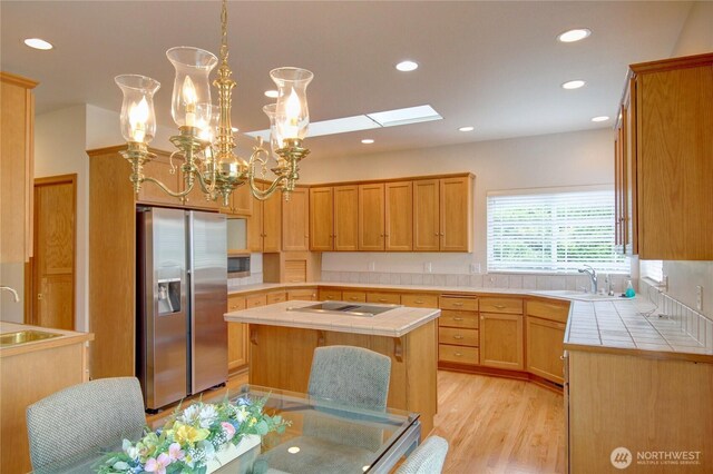 1218 Alpine View Dr, Mount Vernon, WA 98274 - kitchen featuring stainless steel fridge, tile counters, stovetop, recessed lighting, and a center island