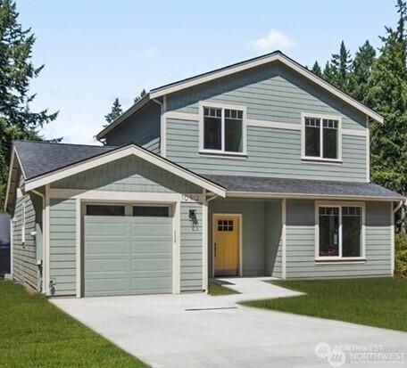 11020 Matthews Way, Anderson Island, WA 98303 - view of front of house featuring driveway, an attached garage, and a front yard