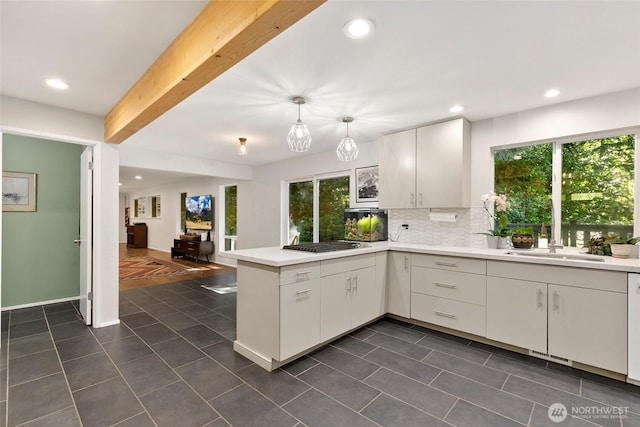 24016 SE 111th St, Issaquah, WA 98027 - kitchen featuring a peninsula, light countertops, dark tile patterned floors, stainless steel gas stovetop, and recessed lighting