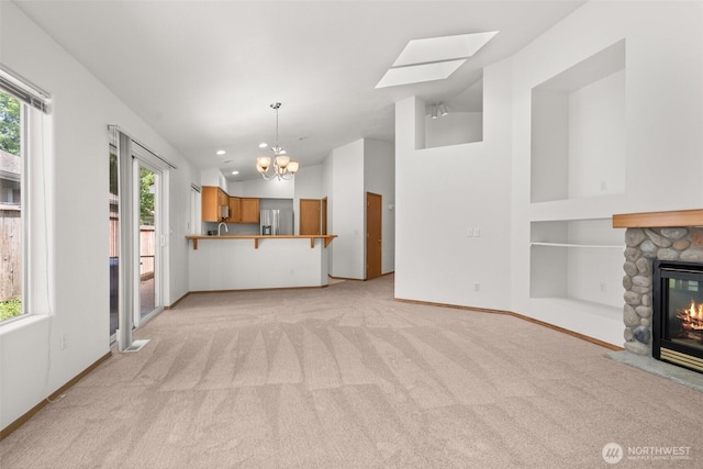 5221 Ivy Hill Ln SE, Lacey, WA 98513 - unfurnished living room with a chandelier, light carpet, a fireplace, lofted ceiling, and a skylight
