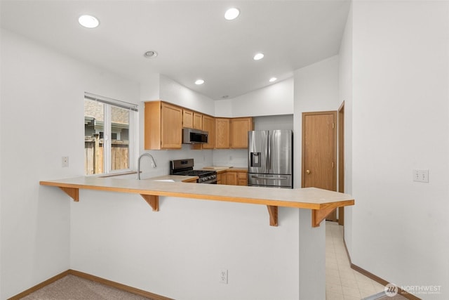 5221 Ivy Hill Ln SE, Lacey, WA 98513 - kitchen featuring appliances with stainless steel finishes, a peninsula, light countertops, a kitchen bar, and recessed lighting