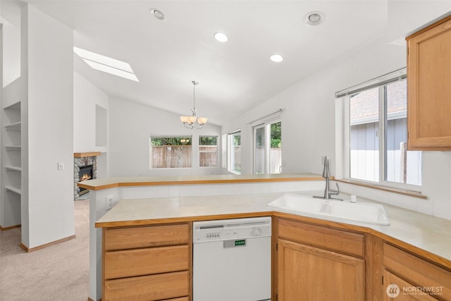 5221 Ivy Hill Ln SE, Lacey, WA 98513 - kitchen with white dishwasher, a peninsula, a stone fireplace, a chandelier, and light colored carpet