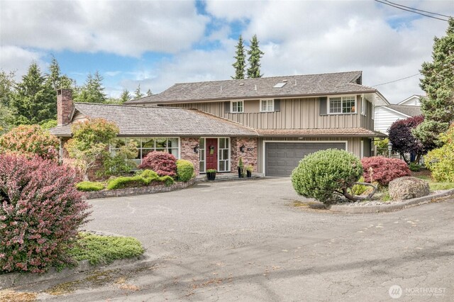 605 Lee Ave, Aberdeen, WA 98520 - traditional-style house featuring asphalt driveway, a chimney, board and batten siding, and an attached garage