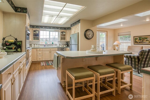 605 Lee Ave, Aberdeen, WA 98520 - kitchen with stainless steel appliances, a breakfast bar area, glass insert cabinets, and dark wood-type flooring