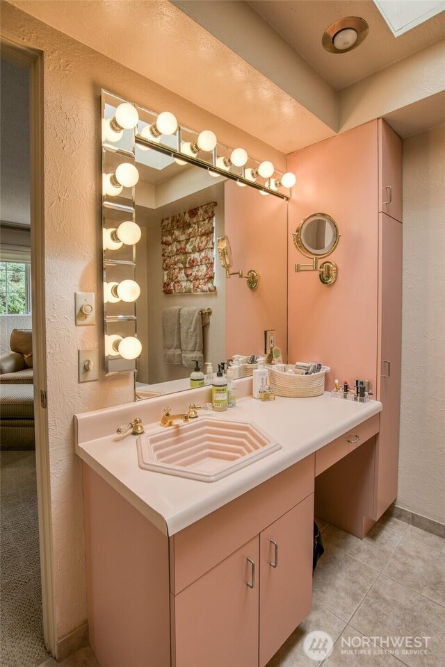 605 Lee Ave, Aberdeen, WA 98520 - ensuite bathroom with vanity, tile patterned flooring, a textured wall, and a skylight