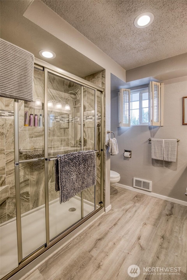 605 Lee Ave, Aberdeen, WA 98520 - bathroom with a stall shower, wood finished floors, a textured ceiling, and recessed lighting