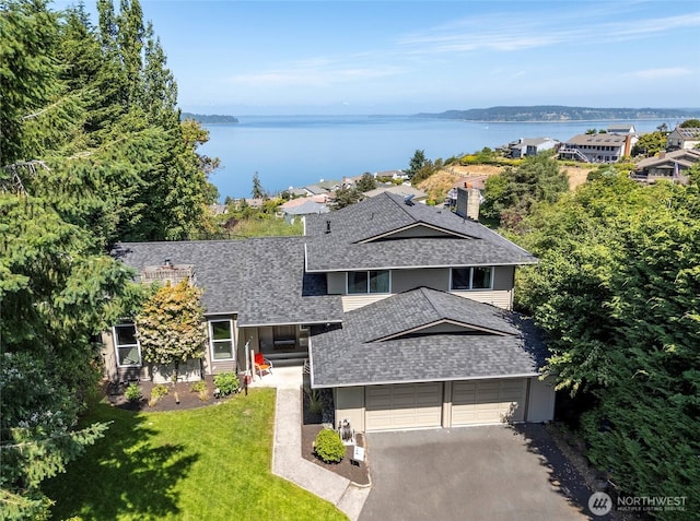 96 Kim Ct, Steilacoom, WA 98388 - view of front facade featuring a shingled roof, a water view, a front lawn, driveway, and a chimney