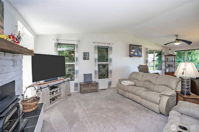 96 Kim Ct, Steilacoom, WA 98388 - carpeted living area with vaulted ceiling, a ceiling fan, plenty of natural light, and a fireplace