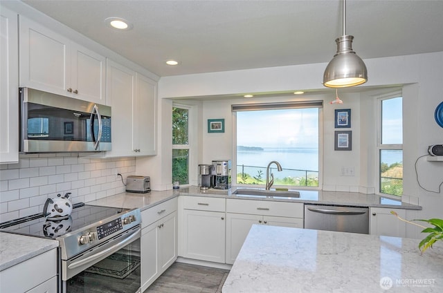 96 Kim Ct, Steilacoom, WA 98388 - kitchen featuring stainless steel appliances, white cabinetry, backsplash, recessed lighting, and light stone countertops